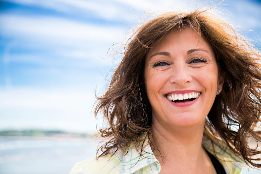Happy middle aged woman with messy hair laughing