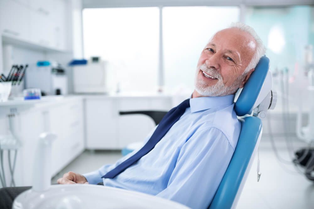 Smiling senior patient seated in a dental chair