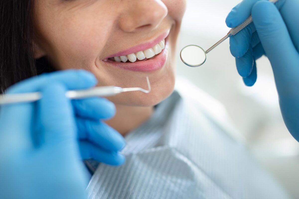 Dentist examining a smiling patient’s teeth
